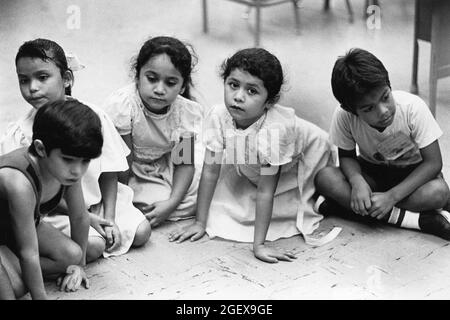 Austin Texas USA, um 1991: Hispanische Kinder im Kindergarten sitzen während der Geschichte an der Walnut Creek Elementary School auf dem Boden. ©Bob Daemmrich Stockfoto