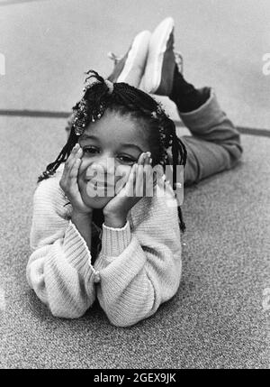 Austin Texas USA, um 1991: Schwarzes Mädchen der 5. Klasse entspannt sich auf dem Boden des Fitnessraums der Walnut Creek Elementary School. ©Bob Daemmrich Stockfoto