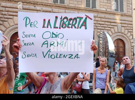 Florenz, Italien. August 2021. Am 21. August 2021 protestieren Menschen gegen den „Green Pass“, das Impfstoffzertifikat Covid 19, Florenz, Italien. Der Green Pass ist derzeit obligatorisch, um durch Italien und die EU zu reisen und Orte wie Restaurants, Kinos, Museen usw. zu betreten.in mehr als 20 italienischen Städten, darunter Rom, Turin, Mailand, Neapel und vielen anderen, fordern Demonstranten die Regierung auf, Menschen frei zu lassen, sich impfen zu lassen oder nicht. Auf dem Plakat steht: 'Für Freiheit - ohne Hass, Waffen und Gewalt'.(Elisa Gestri/Sipausa) Quelle: SIPA USA/Alamy Live News Stockfoto