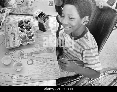 Austin Texas USA, 1984: Patrick Skeaton, ein behinderter Junge im Rollstuhl, zeichnet sich während der Kunstklasse in der Grundschule mit einem Bein. ©Bob Daemmrich Stockfoto