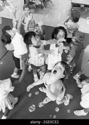 Austin Texas USA, um 1999: Vorschüler spielen mit Seifenblasen in ihrem Kindertagesraum. ©Bob Daemmrich Stockfoto