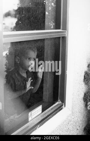 Austin Texas USA, um 1999: Der Vorschuljunge schaut aus dem Fenster des Kindertagesgebäudes. HERR Creative World Day Care. ©Bob Daemmrich Stockfoto