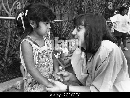 Austin Texas USA, um 1999: Lehrerin, die mit einem Mädchen im Vorschulalter auf einem Spielplatz in einer privaten Tagesstätte interagiert. ©Bob Daemmrich Stockfoto