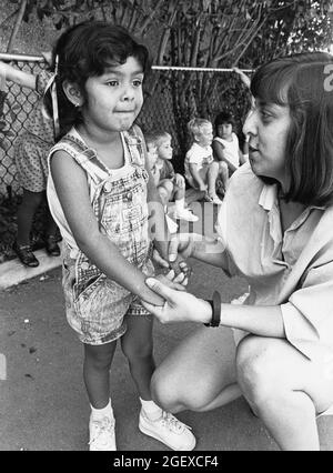 Austin Texas USA, um 1999: Lehrerin, die mit einem Mädchen im Vorschulalter auf einem Spielplatz in einer privaten Tagesstätte interagiert. ©Bob Daemmrich Stockfoto