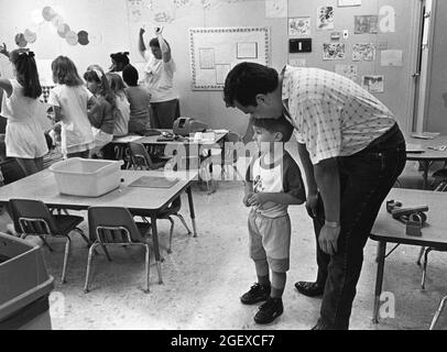 Austin Texas USA, um 1999: Männlicher Lehrer lehnt sich an, um jungen Jungen im Klassenzimmer in einer privaten Tagesstätte zuzuhören. ©Bob Daemmrich Stockfoto