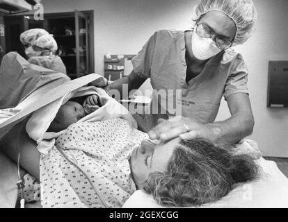 Austin Texas USA, 1982: Geburtsgeschichte, die 1982 im Austin American-Statesman lief. Die anwesende Krankenschwester stellt das Neugeborene zur Mutter hin und her. File 82-48 Box #12 Geburt war 6-2-1982. ©Bob Daemmrich Stockfoto