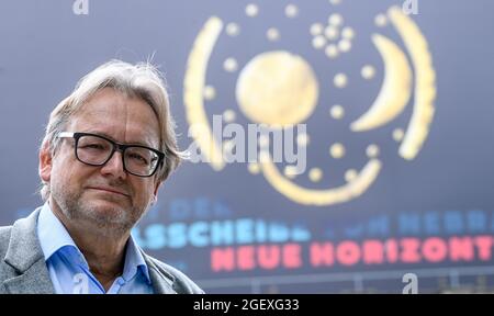 17. August 2021, Sachsen-Anhalt, Halle (Saale): Harald Meller, Landesarchäologe und Honorarprofessor am Institut für Europäische Archäologie der Martin-Luther-Universität Halle-Wittenberg, steht vor dem Landesmuseum unter einem Banner mit einem Bild der Himmelsscheibe von Nebra. Als der Archäologe Meller im März 2001 seine Arbeit am Landesmuseum Halle begann, war die Einrichtung bereits seit Jahren geschlossen. Weniger als ein Jahr später, im Februar 2002, wurde die Himmelsscheibe von Nebra mit Hilfe von Meller in einem Hotel in Basel, Schweiz, gerettet. Zwanzig Jahre später gilt das Museum in Halle als Cent Stockfoto