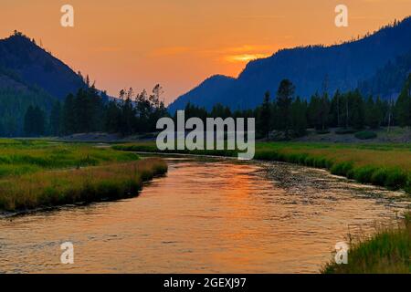 Das Nachglühen der untergehenden Sonne reflektiert auf dem Madison River entlang der West Entrance Road auf der Westseite des Yellowstone National Park, Wyoming USA. Stockfoto