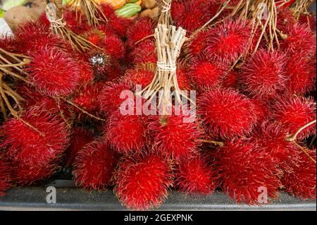 Rote Rambutan-Frucht (Nephelium lappaceum) zum Verkauf auf einem lokalen Markt, Sabah, Borneo Stockfoto