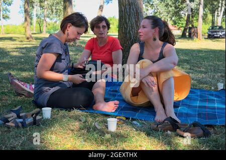 Drei reife Frauen, die im Park picknicken Stockfoto