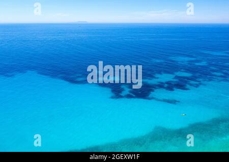 Luftaufnahme des türkisfarbenen Meeres und eines Paares mit Schwimmflossen auf einem schwimmenden Luftbett, aufgenommen von der Drohne. Albanien, Europa Stockfoto