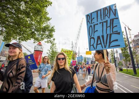Ein junger Protestler sah während der Demonstration, wie er ein Plakat über der Erasmus-Brücke auf dem Weg zum Stadhuisplein hielt.Tausende von Demonstranten gingen auf die Straße in sechs großen Städten der Niederlande. Die Demonstranten zeigten ihre Missbilligung hinsichtlich staatlicher Maßnahmen oder Beschränkungen im Bereich der Unterhaltung und der Covid-19-Pandemie; Beschränkungen, die sie für zweierlei Maß halten. Mit dem Slogan ‘Unmute US' kamen sie in großer Zahl heraus in: Amsterdam, Rotterdam, Groningen, Eindhoven, Nijmenrgan und Utrecht. Demonstrationen fordern, dass der Veranstaltungssektor seine öffnen sollte Stockfoto