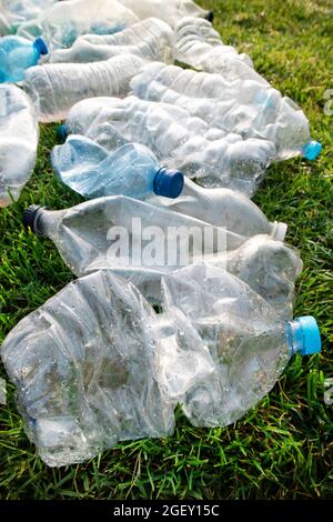 Zeichen der Unhöflichkeit benutzte Plastikflaschen, die auf einer Wiese abgelegt wurden Stockfoto