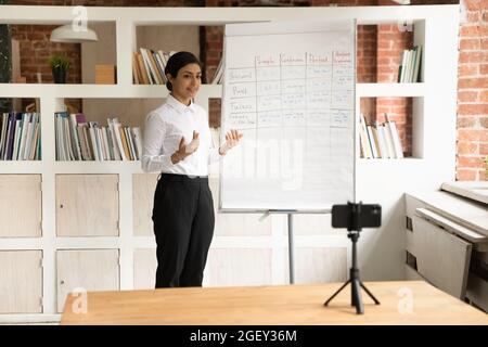 Indische Frau unterrichten Englisch Grammatik Aufzeichnung Webinar-Klasse auf Handy Stockfoto