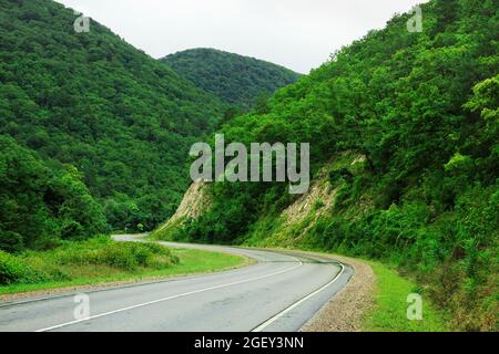 Die Serpentinenstraße durch die Berge führt um die Kurve Stockfoto