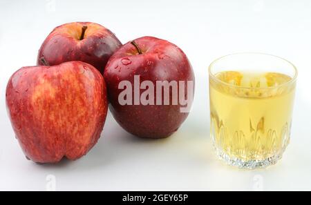Apfelessig in einer Glasschale mit roten Äpfeln im Hintergrund Stockfoto