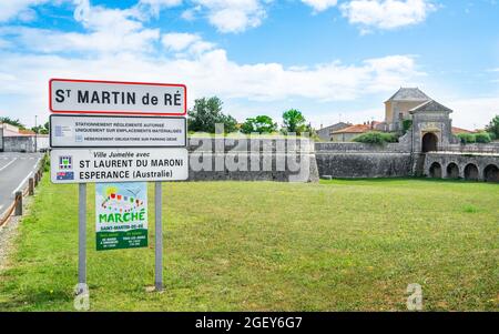 30 July 2021 , Saint-Martin-de-Ré Frankreich : Saint-Martin-de-Ré Stadtschild und Blick auf die alte Stadtbefestigung mit Campani-Tür der Vauban-Zitadelle in Stockfoto