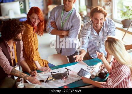 Draufsicht auf das Team, das an der geplanten Videoaufnahme mit Drohne arbeitet und Spaß an der Arbeit hat Stockfoto