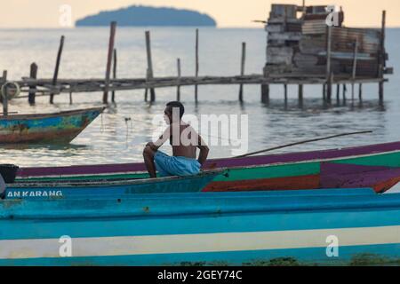 Yenbeser, Indonesien - 14. Okt 2019: Ein Mann bereitet die Boote vor, um am Morgen in der Nähe von Gam Island, Raja Ampat, angeln zu gehen Stockfoto