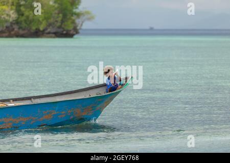 Friwin, Indonesien - 14. Okt 2019: Ein kleiner Junge reist im Bug eines Motorbootes, Raja Ampat, West Papua Stockfoto