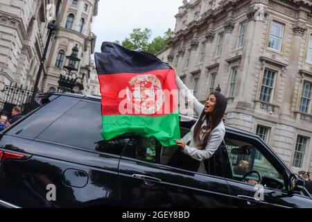 London, Großbritannien. August 2021. Frau schwenkt afghanische Flagge aus dem Auto vor der Downing Street während des Afghanistan-Protests in Whitehall, Quelle: Lucy North/Alamy Live News Stockfoto