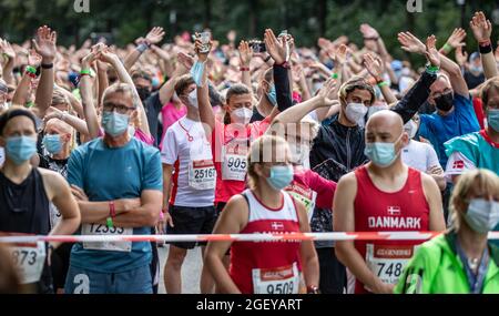 Berlin, Deutschland. August 2021. Leichtathletik, Generali Berlin Halbmarathon 2021: Maskierte Teilnehmer wärmen sich vor dem Startplatz auf. Quelle: Andreas Gora/dpa/Alamy Live News Stockfoto