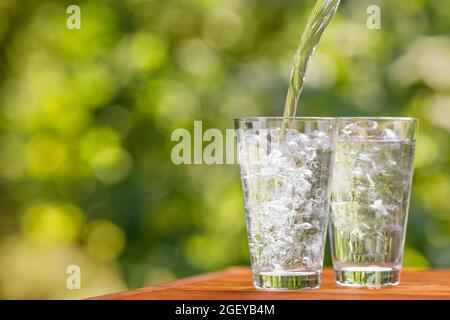 Trinken Gießen in Glas mit Eiswürfeln Stockfoto