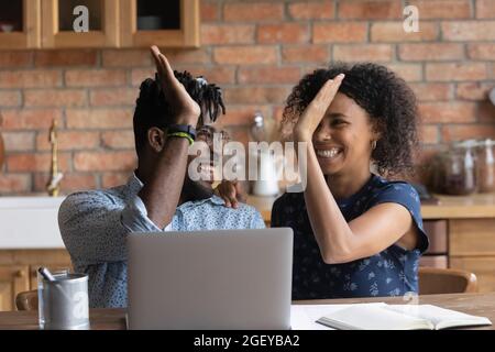Happy aufgeregt Black gemischtes Rennpaar feiert Erfolg am Laptop Stockfoto