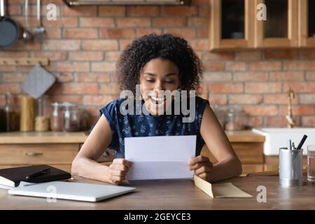 Glückliche tausendjährige afroamerikanische Frau, die gute Nachrichten erhält Stockfoto