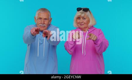 Ältere Oma mit Großvater, der auf die Kamera zeigt und mit glücklicher Ausdruckskraft ausschaut und die Wahl getroffen hat Stockfoto