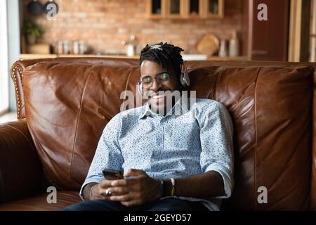 Happy Millenial Hipster Black guy trägt Kopfhörer Stockfoto