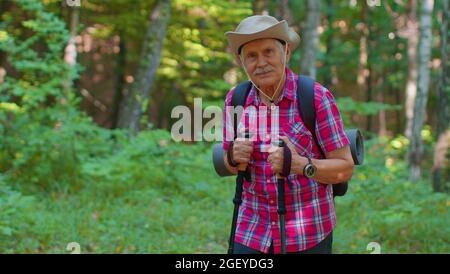 Ältere ältere Touristen Großvater Training Nordic Walking mit Ski-Trekkingstöcken, Wandern in Holz Stockfoto