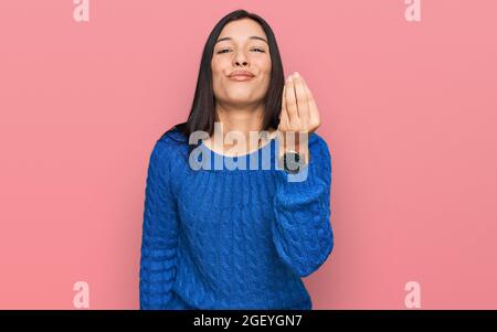 Junge hispanische Frau trägt Freizeitkleidung tun italienische Geste mit Hand und Finger selbstsicher Ausdruck Stockfoto