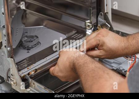 Ein Mann entfernt eine beschädigte, schmutzige Gummidichtung zum Austausch. Stockfoto