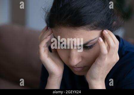Traurige Inderin fühlt sich deprimiert und denkt zu Hause Stockfoto