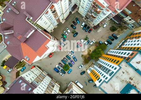 Luftaufnahme von geparkten Autos auf dem Parkplatz zwischen hohen Wohngebäuden. Stockfoto