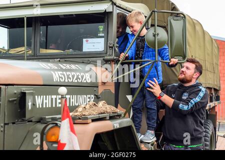 Kilmarnock, Großbritannien. August 2021. Im Ayrshire Classic Car Club wurde eine Oldtimer- und Oldtimer-Ausstellung mit 120 Autos, Lastkraftwagen und Bussen mit Besitzern aus ganz Großbritannien veranstaltet. Glücklicherweise wurden die Einschränkungen von Covid gelockert, und die Show konnte vorausgefahren werden und ist die erste Show dieser Art, die vom Car Club seit März 2020 organisiert wird. Bild von JORDAN WRIGHT, 8 Jahre alt, mit ihrem Vater ALLAN WRIGHT aus Hamilton, der in die Kabine eines amerikanischen 1956 KYSER REO M35A2 Truppentransporters und eines Waffenwagens blickt. Kredit: Findlay/Alamy Live Nachrichten Stockfoto