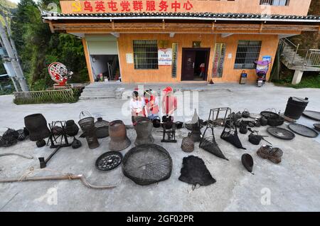 (210822) -- RONGSHUI, 22. August 2021 (Xinhua) -- am 21. August 2021 arrangieren Studenten gesammelte alte landwirtschaftliche Werkzeuge und Lebensgeräte im Dorf Wuying, das an der Grenze zwischen der Autonomen Region Guangxi Zhuang im Süden Chinas und der Provinz Guizhou im Südwesten Chinas liegt. Im Sommer 2021 führte ein ehrenamtliches Team aus Studenten und Mittelschülern lokale Schüler an verschiedenen Aktivitäten wie der Pflege von Setzlingen, dem Lernen über immaterielle Kulturgüter und dem Sammeln alter Bauernwerkzeuge für Museen Teil. (Xinhua/Huang Xiaobang) Stockfoto