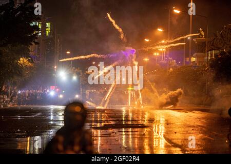 Bangkok, Thailand. 22. August 2021: Die Polizei benutzte mit chemischen Reizstoffen und anderen weniger tödlichen Mitteln versenkte Wasserwerfer, als Demonstranten molotow-Cocktails warfen, Feuerwerke starteten und Ping-Pong-Bomben mit Schleuderschüssen schossen. Informell in Abstimmung mit der im Juli 2020 begonnenen prodemokratischen Protestbewegung haben diese Berufsschülergruppen zunehmend Konfrontationen mit der Polizei ausgelöst, frustriert über die verheerenden Auswirkungen der dritten Covid-19-Welle auf Thailand und die als inkompetent empfundene Regierung im Umgang mit der Krise. Stockfoto