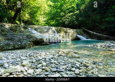 Ein kleiner und schöner Wasserfall in einer tiefen Schlucht in den Bergen des Nordkaukasus. Stockfoto