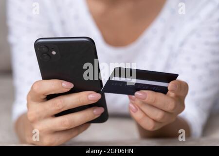 Hände einer Kundin mit Smartphone und Kreditkarte Stockfoto