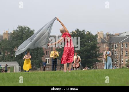 Edinburgh, Schottland, Großbritannien. August 2021. Tanzvorstellung im Freien im Holyrood Park im Rahmen des Edinburgh International Festival. Field - Something for the Future Now wird von Christine Devaney geleitet und bietet ein Ensemble von Künstlern aus Edinburgh, Field is an immersive, Erhebende Arbeiten und Performer reagieren auf die umgebende Landschaft und einander, indem sie einer Reihe von Bewegungen und Live-Soundscores folgen, vor deren Hintergrund Arthur’s Seat steht. Iain Masterton/Alamy Live News. Stockfoto