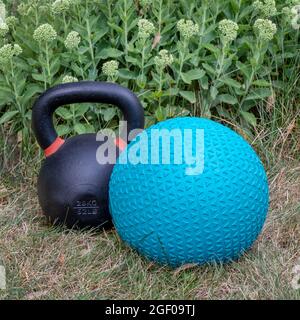 Gummi-Slam-Ball gefüllt mit Sand und Eisen Kugelhantel in einem Hinterhof, Heimstudio, Bewegung und Fitness-Konzept Stockfoto