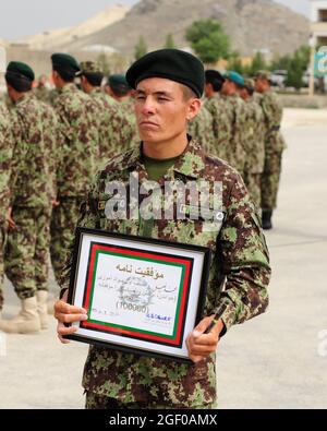 Mohammed Khalil, der Privatkämpfer der afghanischen Nationalarmee, der 100.000ste Absolvent des Basic Warrior Training, der ein Alphabetisierungstraining absolviert hat, wird von Brig mit einer Plakette und einem Stift ausgezeichnet. General Amlaqullah Patyani, Kommandant des Militärausbildungszentrums von Kabul, im Militärausbildungszentrum von Kabul in Kabul, Afghanistan, 28. Juli 2011, in Anerkennung der Leistungen der afghanischen Nationalen Sicherheitskräfte im Bereich Bildung und Alphabetisierung. Grundlegende Kriegerausbildung Kandak 162 absolvierte 1,287 Soldaten, die alle an verschiedenen Zweigschulen der afghanischen Nationalarmee oder dem Consolidated Fielding Center in Kab weiterbilden werden Stockfoto