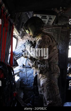 Sgt. Shawn Adams, Schütze auf einem CH-47, scannt sein Gebiet während eines Fluges in der Provinz Uruzgan, Afghanistan, 12. Mai 2013. Die Chinooks, die von Mitgliedern der Bravo Company, des 2. Bataillons, des 104. Luftfahrtregiments der Nationalgarde der Connecticut und Pennsylvania Army betrieben werden, haben seit ihrer Ankunft im Dezember 2012 durch Nachschub-, Rückschritt- und geplante Einsätze eine wichtige Rolle bei der Mission in Afghanistan gespielt. (USA Armeefoto von Sgt. Jessi Ann McCormick) Stockfoto