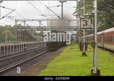 RO-RO (Roll On Roll Off) Zug mit Lastwagen, der am Bahnhof Sawantwadi auf der Konkan Railway, Maharashtra, Indien, kreuzt Stockfoto