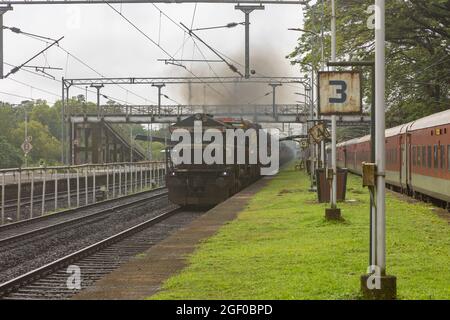 RO-RO (Roll On Roll Off) Zug mit Lastwagen, der am Bahnhof Sawantwadi auf der Konkan Railway, Maharashtra, Indien, kreuzt Stockfoto