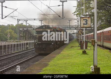 RO-RO (Roll On Roll Off) Zug mit Lastwagen, der am Bahnhof Sawantwadi auf der Konkan Railway, Maharashtra, Indien, kreuzt Stockfoto