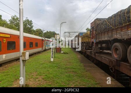 RO-RO (Roll On Roll Off) Zug mit Lastwagen, der am Bahnhof Sawantwadi auf der Konkan Railway, Maharashtra, Indien, kreuzt Stockfoto