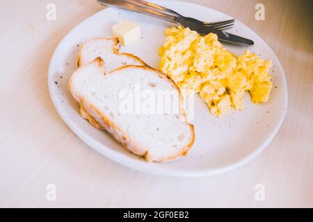 Mascarpone Rühreier mit Knoblauch Toast Essen Frühstück Mahlzeit in Keramikplatte Scheibe. Stockfoto